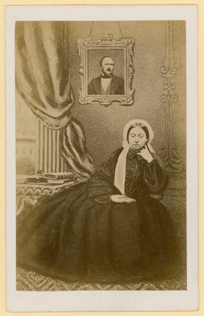 Queen Victoria, when a widow, with a portrait of the Prince Consort behind her by English Photographer