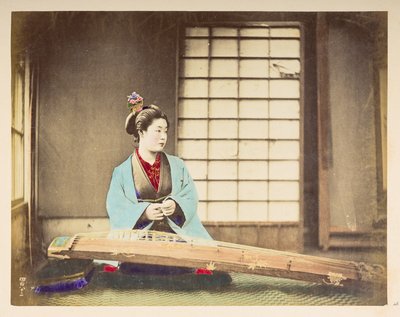 Singing girls [Japan], Studio portrait of a Japanese woman, seated with a stringed instrument (a kind of zither) resting on the floor in front of her by English Photographer