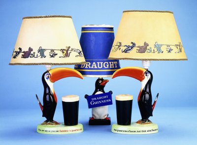 A lampbase modelled as a toucan beside a pint glass by English School