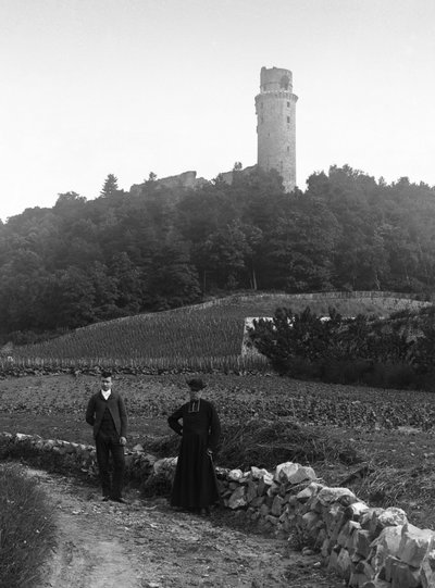 The country cure, accompanied by a young man, posing in front of the tower of Montlhery in Essone. Photography late 19th century. Ducos Collection by French Photographer