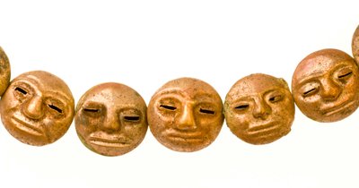 A necklace found around the mummy’s neck with small gold faces. by Ira Block
