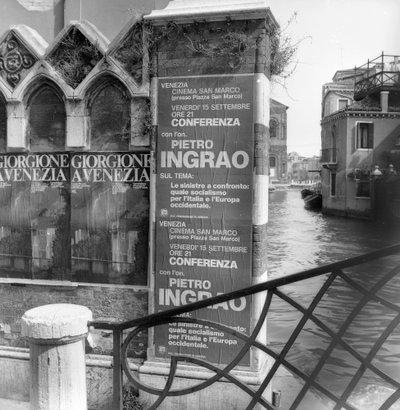 View of a canal in Venice with posters advertising a Giorgione exhibition and a political manifesto in foreground by Italian Photographer