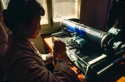 In the commune office a member types on a Chinese typewriter, Chun Xing Commune, Yunnan by James L Stanfield