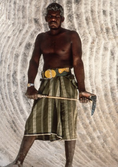 Yemenite man holding a salt pick in old salt mine in ancient city of Shabwah by Lynn Abercrombie
