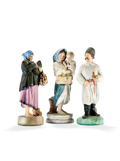 Three porcelain figures depicting two women holding children, and a Cossak with a pipe, late 19th century by School Russian