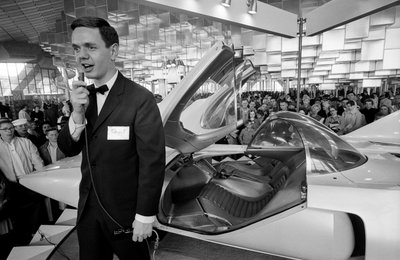 Announcer with futuristic Firebird III experimental gas turbine automobile at General Motors exhibit by Ted Spiegel
