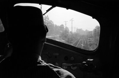 View of Tracks from Cab of a Diesel Locomotive with the Engineer, Pacific Northwest by Ted Spiegel