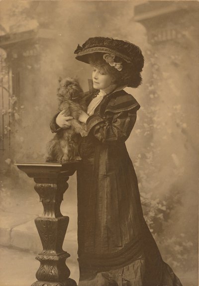 Sarah Bernhardt Standing in a Studio Setting, Holding a Little Black Dog on an Ornate, Carved Wooden Pedestal by Theodore C. Marceau