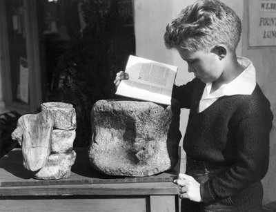 Palos Verdes, California: c.1927 A young boy studies archeology with the use of a fossilized prehistoric vertebrae found in the nearby hills. by Unbekannt
