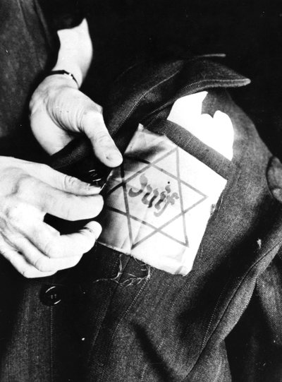 Sewing the Yellow Star Identifying a Jew onto a Jacket, German-occupied Paris by Unbekannt