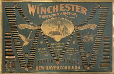 A Winchester Cartridge display board, with a comprehensive selection of metallic, brass and paper-case rifle and shot cartridges arranged in the form of an extended 
