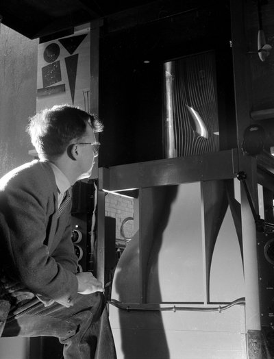 Engineer in wind tunnel with smoke tests under way on a small wing section by Unbekannt