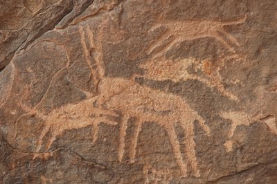 Rock art, Prehistory: Engraving of an antelope attacked by a pack of dogs in the Uweinat massif, Egypt (Period from 8000 to 3000 years BC). Photography by Unbekannt
