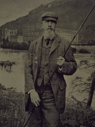 Studio portrait of 8th Duke of Devonshire in tweeds holding fishing rod in front of a printed screen depicting Chatsworth by William M. Timlin