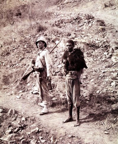 An Italian soldier and an Abyssinian prisoner on the road to Ghinda. by Unknown photographer