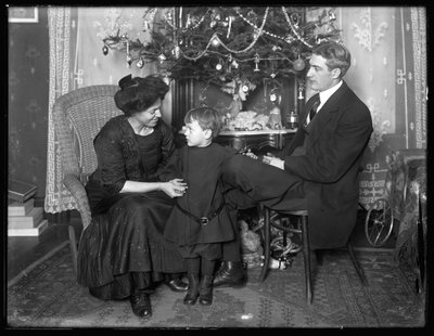 Dan Seymour and family in informal pose, seated beneath a Christmas tree, Christmas 1912 by William Davis Hassler