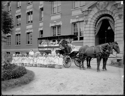 Small Girls Pose in and in Front of a Horse-Drawn Wagon, in Front of an Unidentified Building, Probably the Roman Catholic Orphan Asylum, Kingsbridge, Bronx by William Davis Hassler