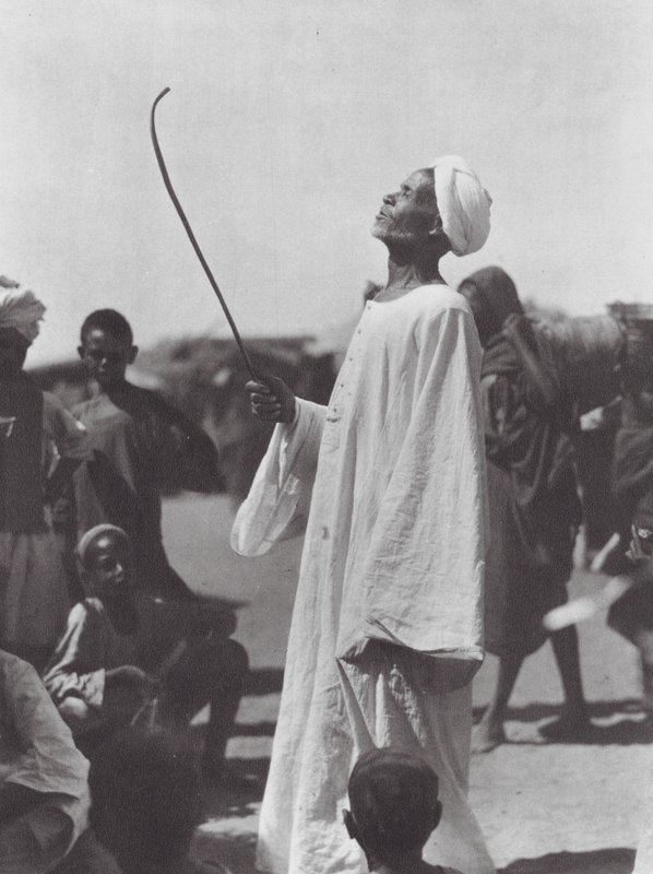Africa: Old man mocking the dancer by Hugo Adolf Bernatzik