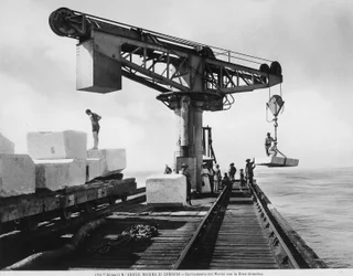 Loading blocks of marble with a hydraulic crane in Marina di Carrara