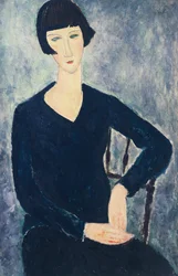Young woman with a fringe or young seated woman in blue dress