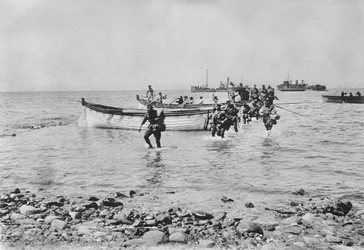 Australian Soldiers Wading Through the Water as They Come Ashore at Anzac Cove, Gallipoli on 25 April 1915 After Being Transported in Landing Boats from Larger Ships in the Background, 25 April 1915