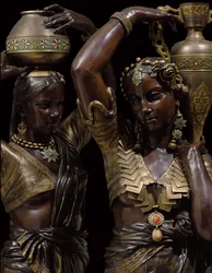 Detail of two bronze torcheres in the shape of Indian women carrying vases