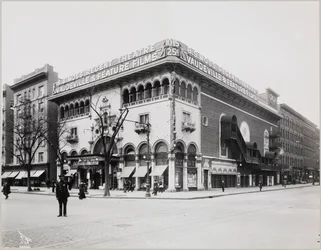 A huge theater with an elaborate facade, complete with Moorish arches and balconies. A large sign on top of the building reads 