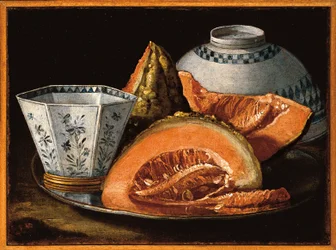 Melon and an octagonal cup on a silver charger, an upturned bowl behind
