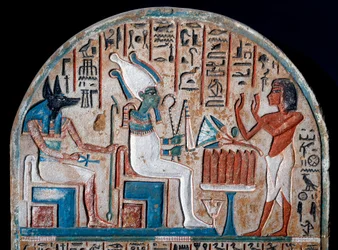 Egyptian antiquity: Nanai stele representing worshipping Osiris and Anubis, deity of the dead who holds the key of life in the shape of an Ankh. Painted limestone. End of the 18th dynasty. 14th century BC. Turin, Egyptian Museum