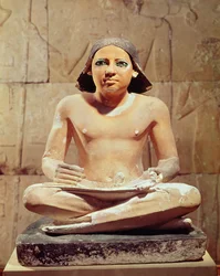 Scribe seated cross-legged holding a papyrus scroll, from Saqqara, Old Kingdom