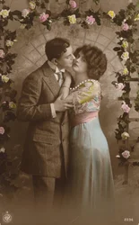 Couple standing under an arch of roses