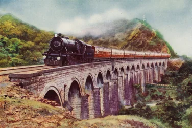 4-6-2 steam locomotive of the Bombay, Baroda and Central India Railway hauling the Frontier Mail passing over a viaduct between Bombay and Delhi