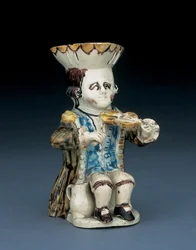 Fiddler Toby jug, his hat with brown and yellow scalloped edge, his brown hair incised and tied en queue with a white rosette, in a washed brown frock coat, c. 1770