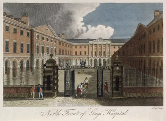 View of the north front of Guys Hospital, Southwark, showing a man being stretchered through the front gates