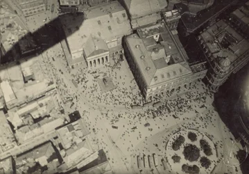[Cityscape with blimp shadow]