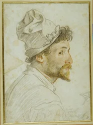 Head and shoulders of a bearded man wearing a cap