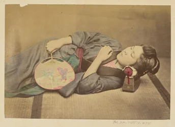 Sleeping Japanese woman holding a fan