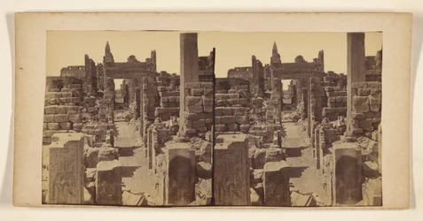 Ruins with carved figures on walls in foreground