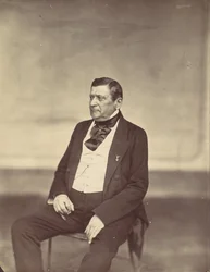 Seated Man in White Vest and Dark Coat