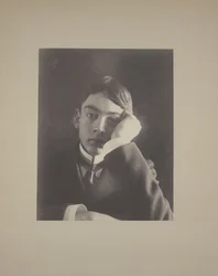 Boy in Suit with Hand Against Face