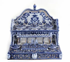 French calligraphy: Writing in porcelain of Gien, with a total length of 40 centimetres, this piece is very representative of the 18th century. There are 5 inkbeds on two stages, as well as a rectangular plumboard. Paris, the pen museum.
