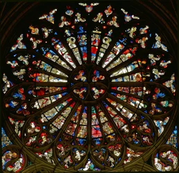 Rose window depicting the Coronation of the Virgin surrounded by angels with Instruments of the Passion and musical instruments