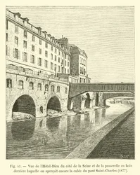 View of the Hotel-Dieu from the Seine side and the wooden footbridge behind which the abutment of the Saint-Charles bridge can still be seen, 1877