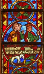 Window w213 depicting a scene from the life of St Thomas: at the banquet a dog brings in the cupbearer