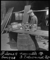 Frank Jones painting a decorative panel, 20th century