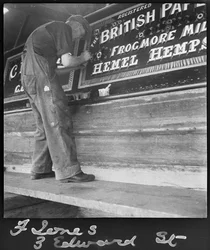 Frank Jones painting the name panel on a barge, 20th century