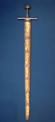 Imperial Sword of the Holy Roman Emperors with partially gilt pommel and cross-bar, the hilt bound with silver wire and the scabbard consisting of fourteen gold foil plaques chased with sovereign figures