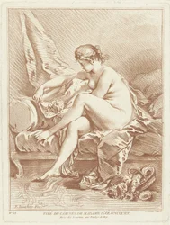 Nude woman sitting on a bed with flowers