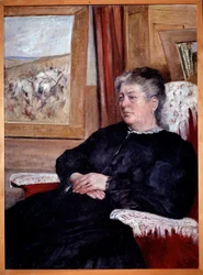 An old woman in an armchair wearing a black dress