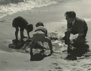 Three kids playing with sand at the beach